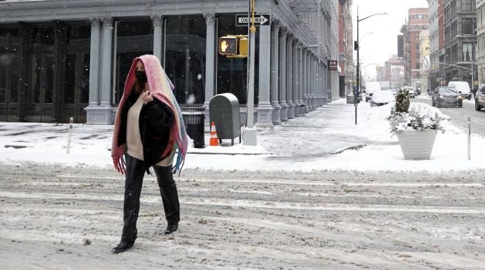Una persona camina por una calle de Nueva York cubierta por la nieve, en una fotografía de archivo.