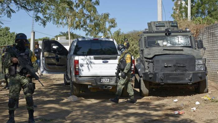 Soldados montan guardia junto a un vehículo del Ejército destruido durante el operativo para arrestar a Ovidio Guzmán, alias “El Ratón”.