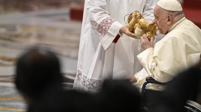 El papa besa una estatua del Niño Jesús durante la celebración de la Epifanía.