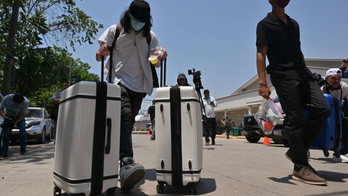 Hombres salen del aeropuerto Ramón Villeda Morales, donde llegaron autodeportados desde Estados Unidos, en San Pedro Sula, a 180 km al norte de Tegucigalpa, el 19 de mayo de 2025.