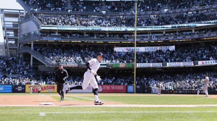 Fotografía de archivo en la que se registró a Aaron Judge (c-i), jardinero y bateador estrella de los Yanquis de Nueva York, tras conectar un jonrón en el Yankee Stadium.