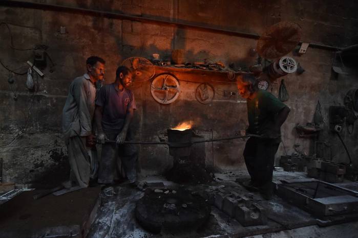 Obreros trabajan en una fábrica en vísperas del Día Internacional de los Trabajadores.