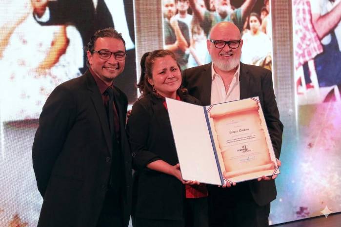 La viceministra de Cultura Arianne Benedetti otorga el reconocimiento a Edwin Cedeño.