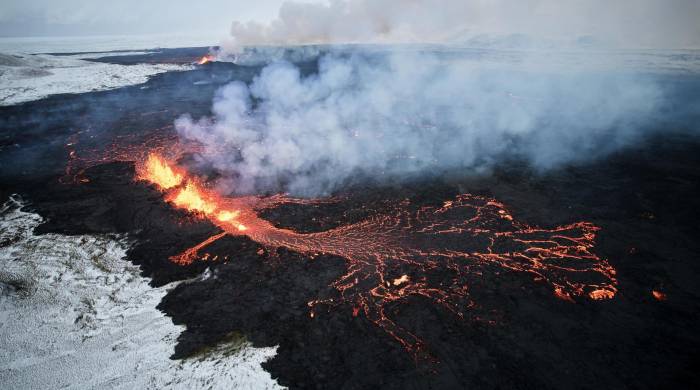 Fotografía aérea tomada con un drone muestra lava y humo saliendo de una fisura volcánica durante una erupción cerca de la ciudad de Grindavik, en la península de Reykjanes (Islandia).