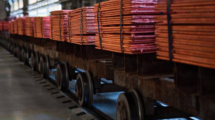 Pilas de hojas de cobre atadas con cintas en vagones de ferrocarril en almacén en una planta de refinería metálica.