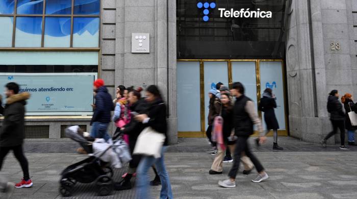 Peatones caminan frente a la sede de Telefónica en Madrid el 3 de diciembre de 2023.