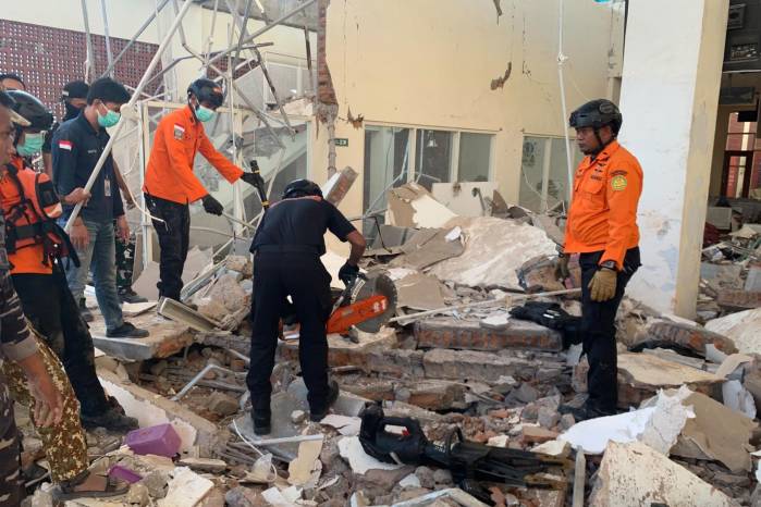 Fotografía cedida por la Agencia Nacional de Búsqueda y Rescate de Indonesia (Basarnas) de sus integrantes trabajando en un edificio derrumbado tras un terremoto de 7,7 registrado este sábado, en la isla de Flores (Indonesia).