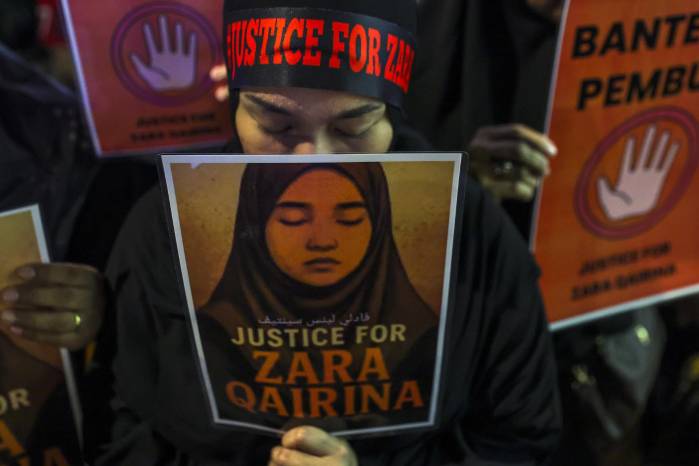 Una ciudadana malasia muestra en una manifestación una fotografía de Zara Qairina, una niña de 13 años que fue encontrada muerta cerca de su escuela en Sabah.