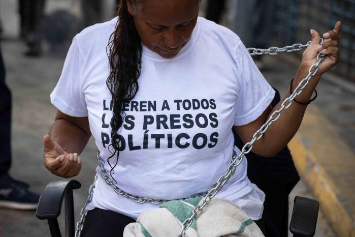 Una persona se encadena para protestar por el incumplimiento de la promesa hecha por el presidente del Parlamento, Jorge Rodríguez, sobre la liberación de todos los detenidos en Caracas (Venezuela).