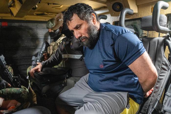 El narcotraficante José Adolfo Macías Villamar 'Fito' (d), es custodiado este miércoles, en Guayaquil (Ecuador). ´Fito' llegó a la Base aérea de Guayaquil, tras ser capturado en la ciudad de Manta, para ser recluido en la cárcel de máxima seguridad La Roca.