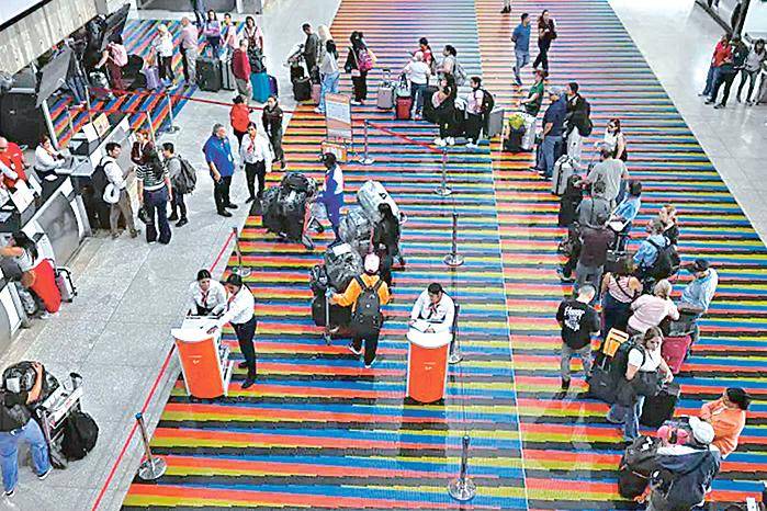 Pasajeros hacen cola en un mostrador del Aeropuerto de Maiquetía, en Caracas (Venezuela).