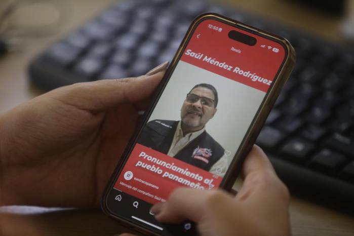 Una persona observa en un celular la imagen del líder sindical panameño Saúl Méndez este lunes, en Ciudad de Panamá (Panamá). Méndez, quien está en paradero desconocido con una orden de captura internacional tras romper su asilo en Bolivia la semana pasada.