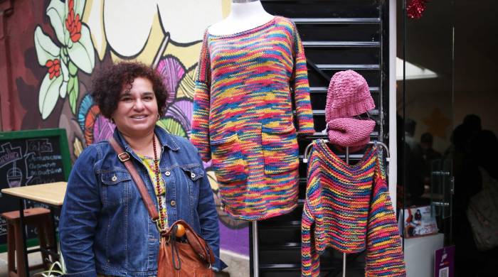La diseñadora Claudia Pérez posa junto a prendas confeccionadas por internas de centros penitenciarios, el 6 de febrero de 2024, en La Paz (Bolivia).