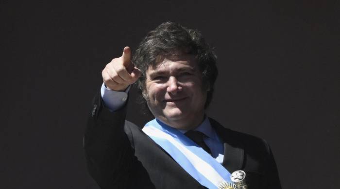 El nuevo presidente de Argentina, Javier Milei, hace gestos desde un balcón del palacio de gobierno de la Casa Rosada.