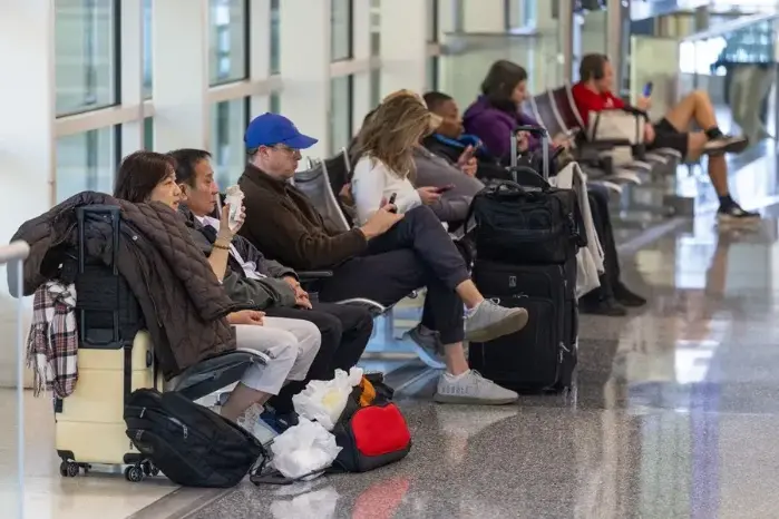 Viajeros que esperan conocer el estado de sus vuelos, en el Aeropuerto Ronald Reagan de Washington, este 7 de noviembre de 2025.