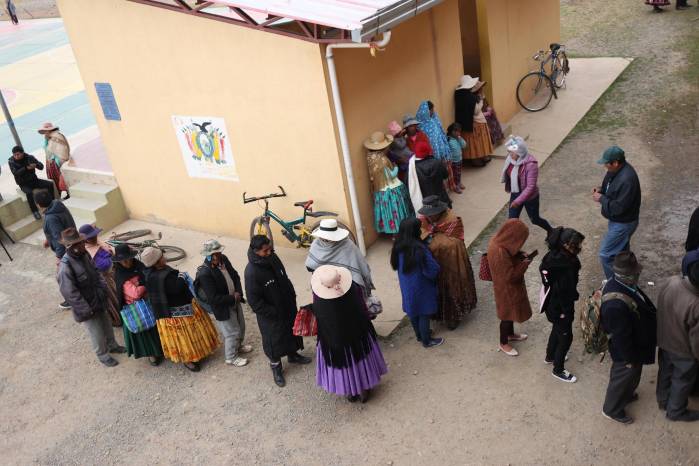 Personas esperan en una fila este domingo, para votar en la segunda vuelta electoral en la comunidad de Laja (Bolivia).