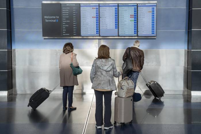 Varios pasajeros observan los monitores del aeropuerto John F. Kennedy este viernes, en la ciudad de Nueva York.