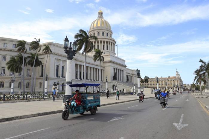 Un triciclo y varias motocicletas eléctricas circulan frente al Capitolio este martes en La Habana (Cuba).