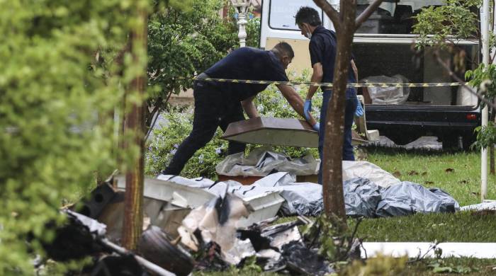 Profesionales del Instituto de Medicina Legal cubren los cuerpos de las personas fallecidas hoy en un accidente de avioneta, en Jaboticabal, estado de Sao Paulo (Brasil). EFE/ Luciano Claudino