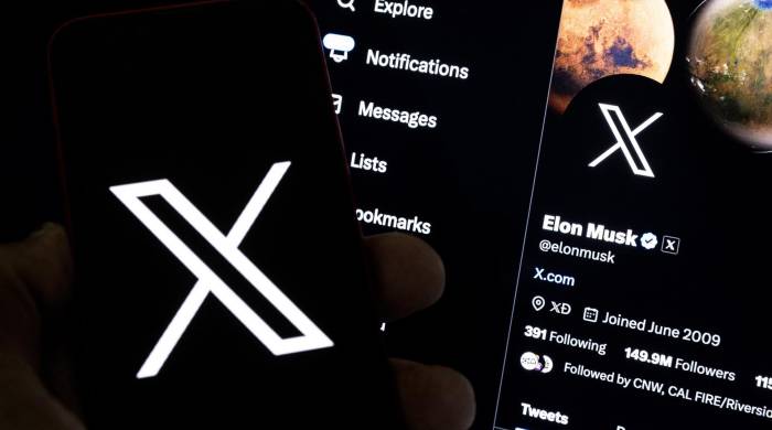 Una imagen ilustrativa muestra a un usuario sosteniendo un teléfono móvil con el logo 'X' frente a la página de Elon Musk.