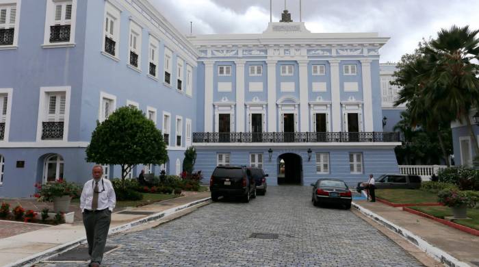 Fachada del Palacio de Santa Catalina, sede del Gobierno de Puerto Rico, con las banderas estadounidense, puertorriqueña y española.