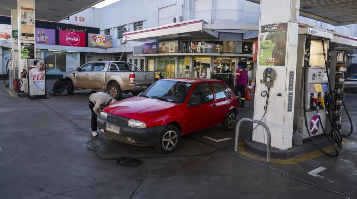 La gente pone aire en los neumáticos de sus autos en una estación de servicio en Salto, Uruguay.