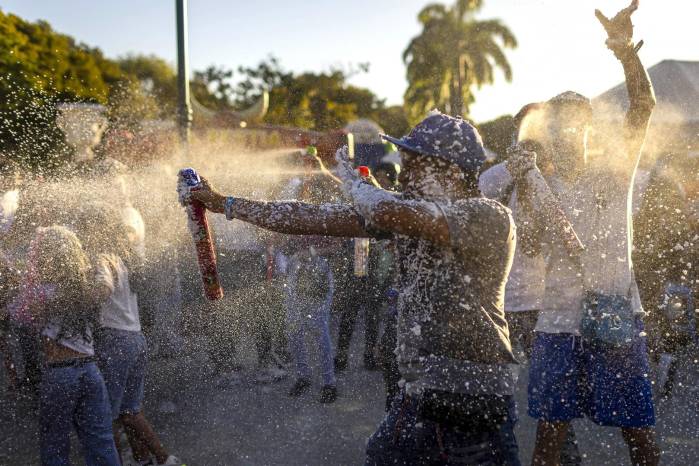 Personas juegan con espuma durante las actividades del carnaval este lunes, en el paseo Los Próceres en Caracas (Venezuela).