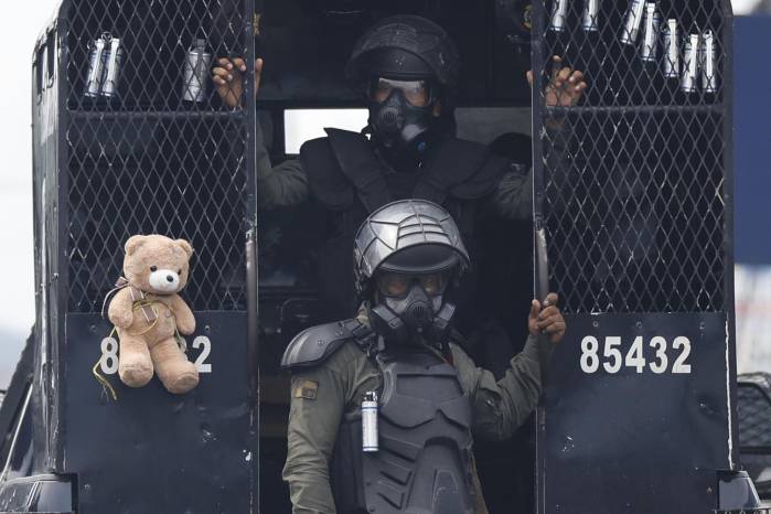 Integrantes de la Unidad de Control de Multitudes (UCM) bajan de un vehículo durante una manifestación esté sábado, en Changuinola, Bocas del Toro (Panamá). La provincia de Bocas del Toro amaneció con las telecomunicaciones cortadas y bajo el estado de urgencia decretado por el Gobierno.