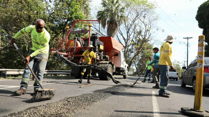 Trabajadores del MOP realizando reparaciones y mantenimientos de la via como parte del plan Tapa hueco.