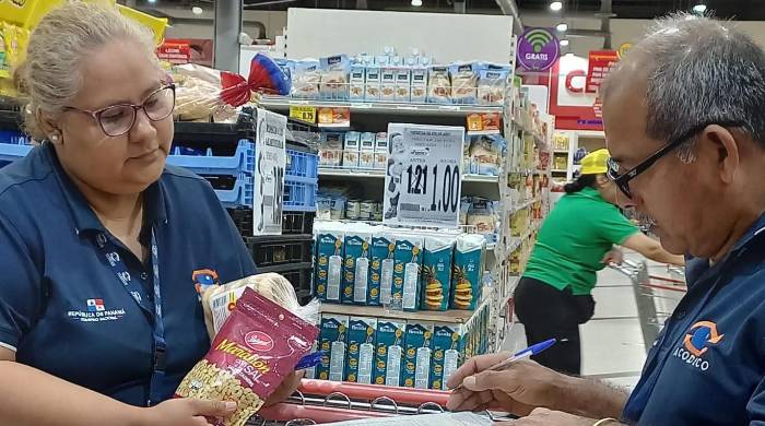 En la foto personal de la Acodeco revisa los productos para verificar el cumplimiento de la Ley 45 de 2007.