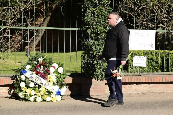 Fanático llevando un ramo de flores frente al cementerio privado El Prado este domingo en Rosario (Argentina). Donde Lionel Messi y su familia despidieron a su padre Jorge Messi.