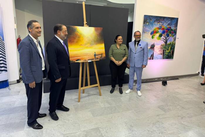 Machado, vestido de traje azul claro, devela una de sus obras en la inauguración del pasado 25 de febrero.
