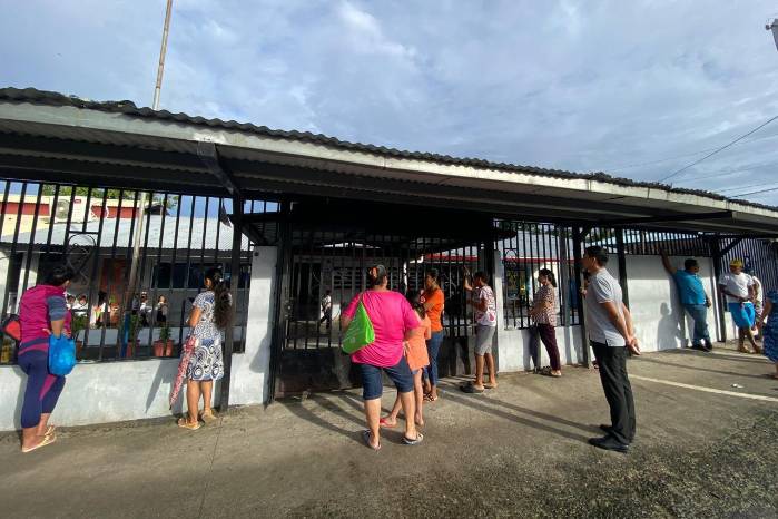 Padres de familia a la espera de sus hijos en un colegio público en Panamá.