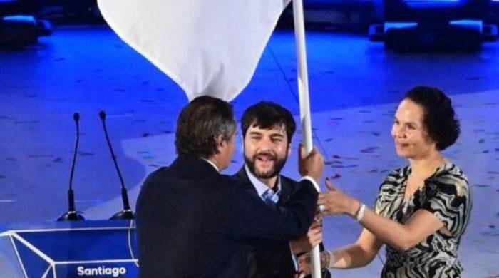 El presidente de Panam Sports, Neven Ilic (Izq.), entrega la bandera continental a las autoridades de Barranquilla, tras culminar los juegos de Santiago.
