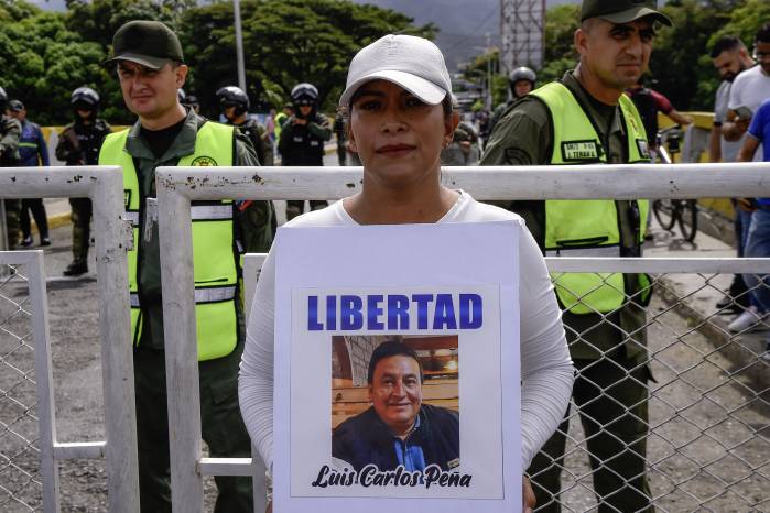Una mujer colombiana sostiene una foto de un familiar detenido en Venezuela durante una protesta en el Puente Internacional Simón Bolívar.