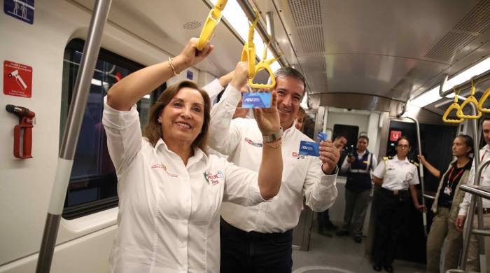 La presidenta del Perú, Dina Boluarte (i), y el ministro peruano de Transportes y Comunicaciones, Raúl Pérez Reyes (d), muestran las tarjetas del Metro durante su primer recorrido hoy, en Lima (Perú).