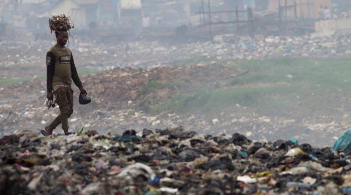En la imagen de archivo, un hombre transporta cables sobre su cabeza en el vertedero de Agbogbloshie, un barrio de Accra, capital de Ghana, considerado el mayor vertedero de basura electrónica del continente Africano. EFE/A. Carrasco Ragel