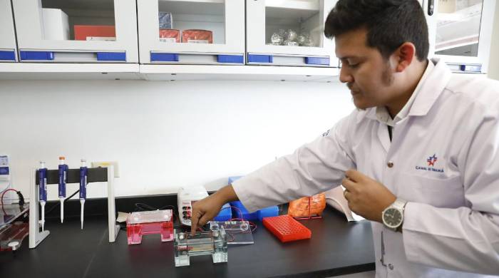 Personal del laboratorio explica a los medios un método de análisis de muestra de agua.