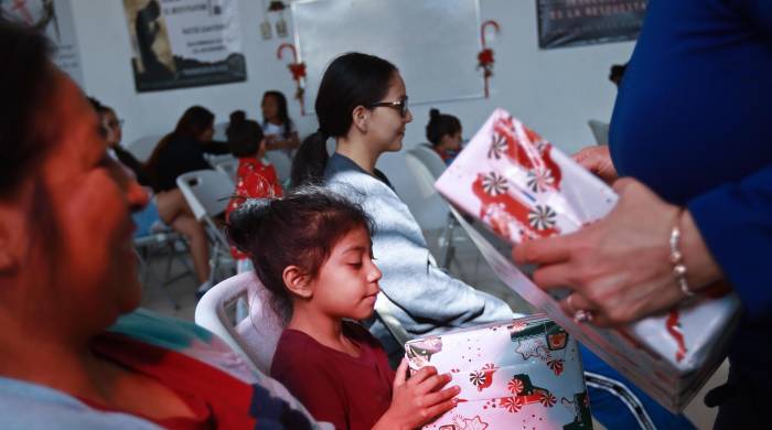 Migrantes que pasan la Navidad en el albergue 'El buen samaritano' reciben regalos, el 24 de diciembre de 2023, en Ciudad Juárez Chihuahua (México).
