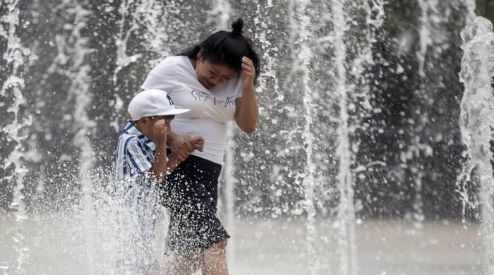 Foto de archivo de dos personas que se refrescan en una fuente de la Ciudad de México (México) para combatir las altas temperaturas. EFE/Isaac Esquivel