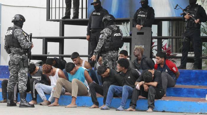 Policías custodian a los detenidos de un grupo armado por la toma temporal de un canal de televisión este 9 de enero, en Guayaquil (Ecuador).