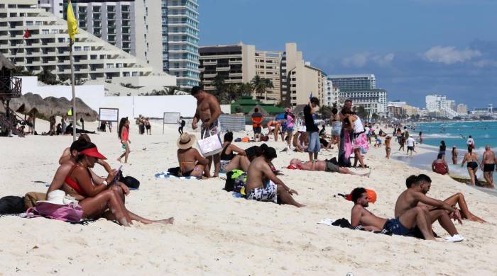 Fotografía de archivo que muestra turistas mientras descansan en una playa en Cancún, en Quintana Roo, México.
