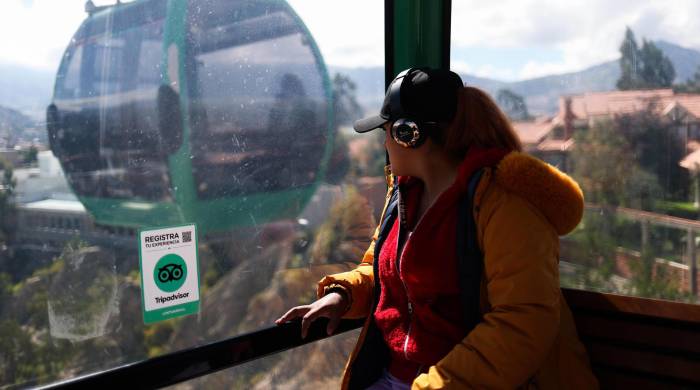Una mujer viaja en una cabina del transporte por cable Mi Teleférico, el 27 de marzo de 2024 en La Paz (Bolivia).