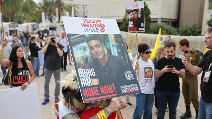 La gente reacciona mientras se reúne viendo una transmisión en vivo en una pantalla grande que informa sobre la liberación del soldado estadounidense-israelí Edan Alexander, en la plaza de los rehenes frente a la base militar de Kirya en Tel Aviv.
