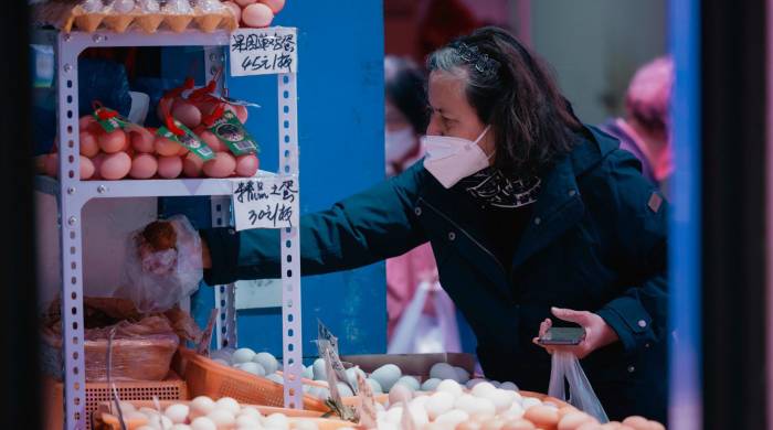 Una mujer compra comida en el mercado húmedo, en Shanghai. EFE/EPA/ALEX PLAVEVSKI
