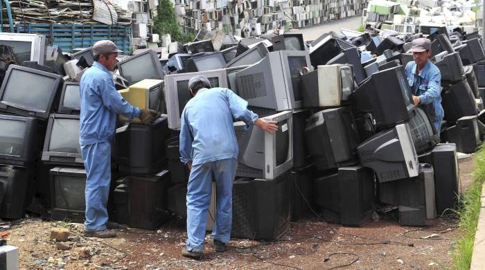 Trabajadores desarman electrodomésticos y artículos electrónicos en un centro de reciclaje en Tieling City, al noreste de China, en una imagen de archivo.