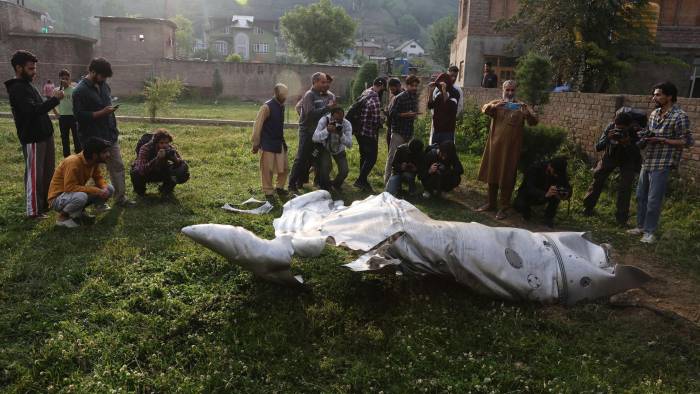 La gente se encuentra de pie cerca de la parte dañada de un avión no identificado en un complejo de la mezquita en Pampore, en las afueras de Srinagar, India, el 07 de mayo de 2025.