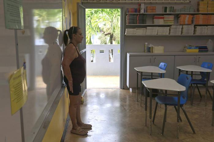 La conserje de la Escuela superior Juan Quirindongo Morell, Nydia Vázquez, muestra el salón de clase donde estudió el cantante Bad Bunny.