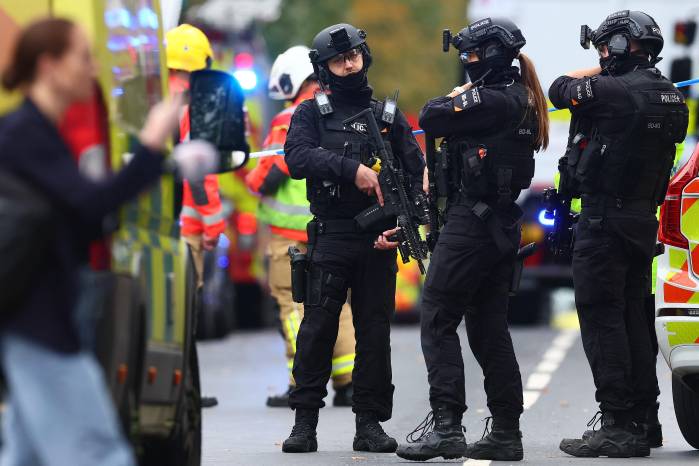 Policías armados se encuentran con sus armas frente a la sinagoga de la Congregación Hebrea de Heaton Park en Crumpsall, al norte de Manchester.