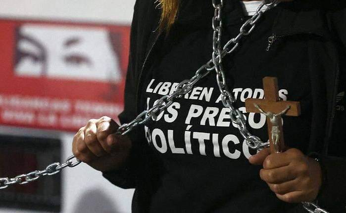 Una persona sostiene un crucifijo y unas cadenas para exigir la liberación de los presos políticos.